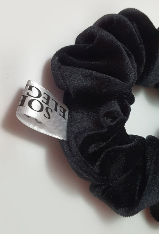 Elegant black velvet scrunchie with a plush, luxurious texture.