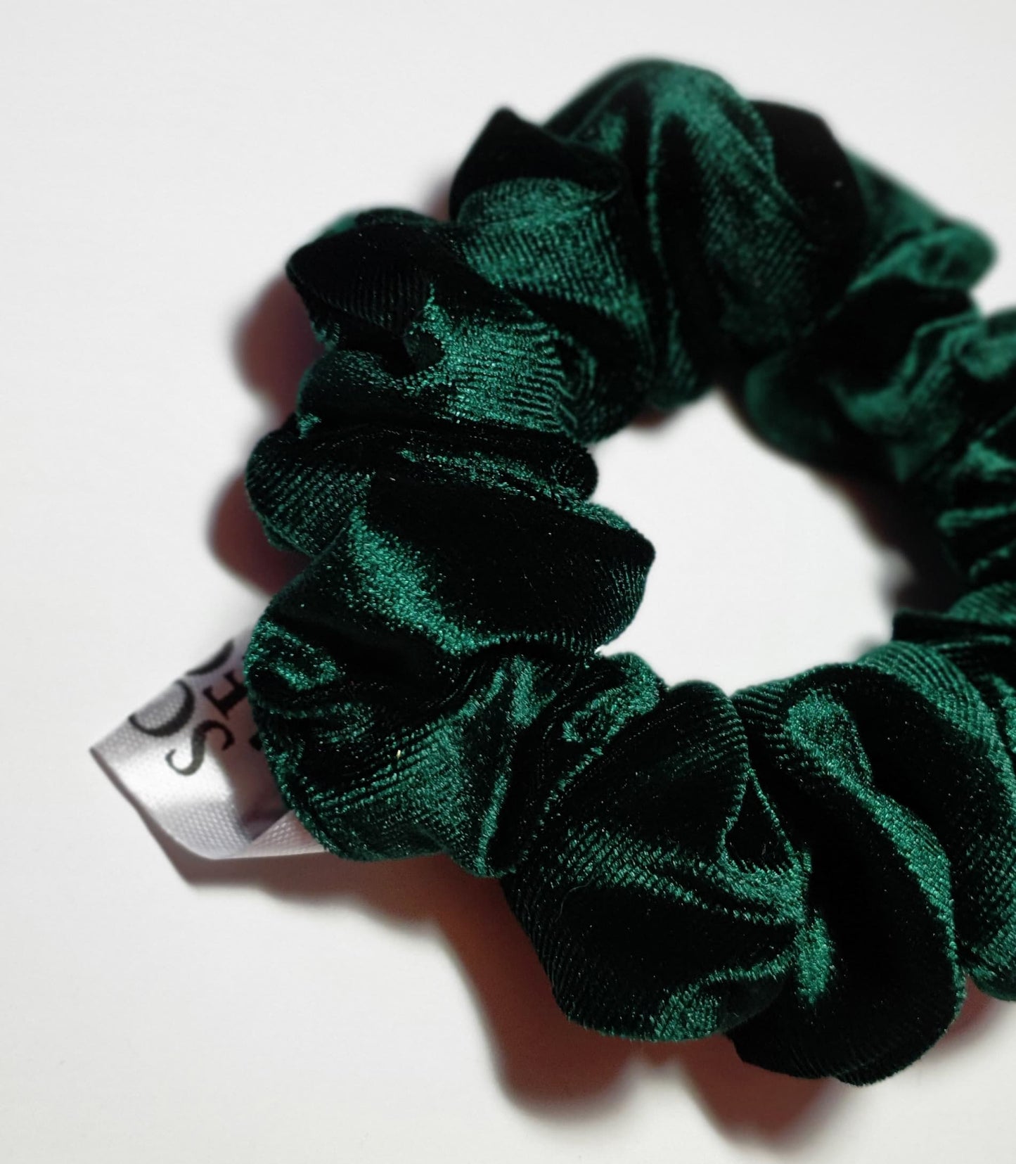 Deep green velvet scrunchie with a plush feel, designed to enhance your hair with a chic and stylish look.
