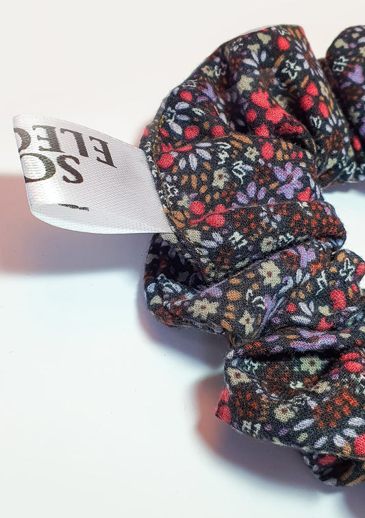 The Mystery Rose scrunchie can be styled in a ponytail, showing its elegant soft pink color and smooth fabric that complements any outfit effortlessly.