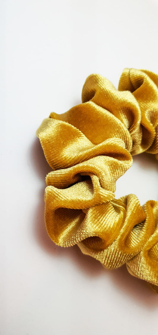 the yellow Velvet Scrunchie by Softandelegant displayed on a white flat surface with a minimalist background, highlighting its luxurious velvet fabric.
